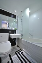 Un baño moderno con inodoro, lavamanos y ducha de vidrio.