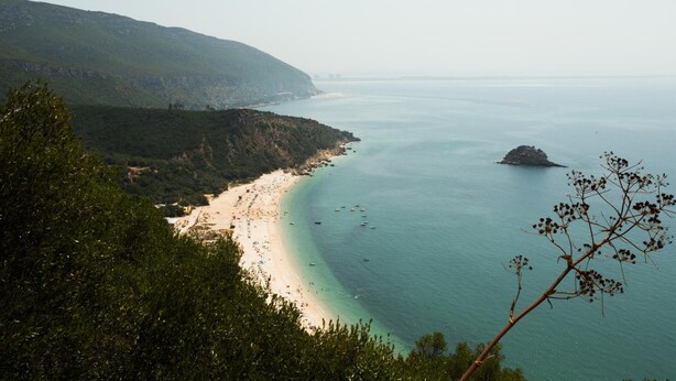A coastal landscape with a beach, clear waters, and a small island. - Hotel Solaris (Setubal)