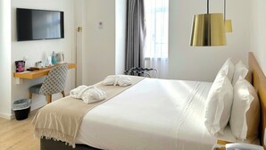 A hotel room with a bed, a desk, a chair, a TV, a telephone, and a window with curtains. - Hotel Solaris (Setubal)