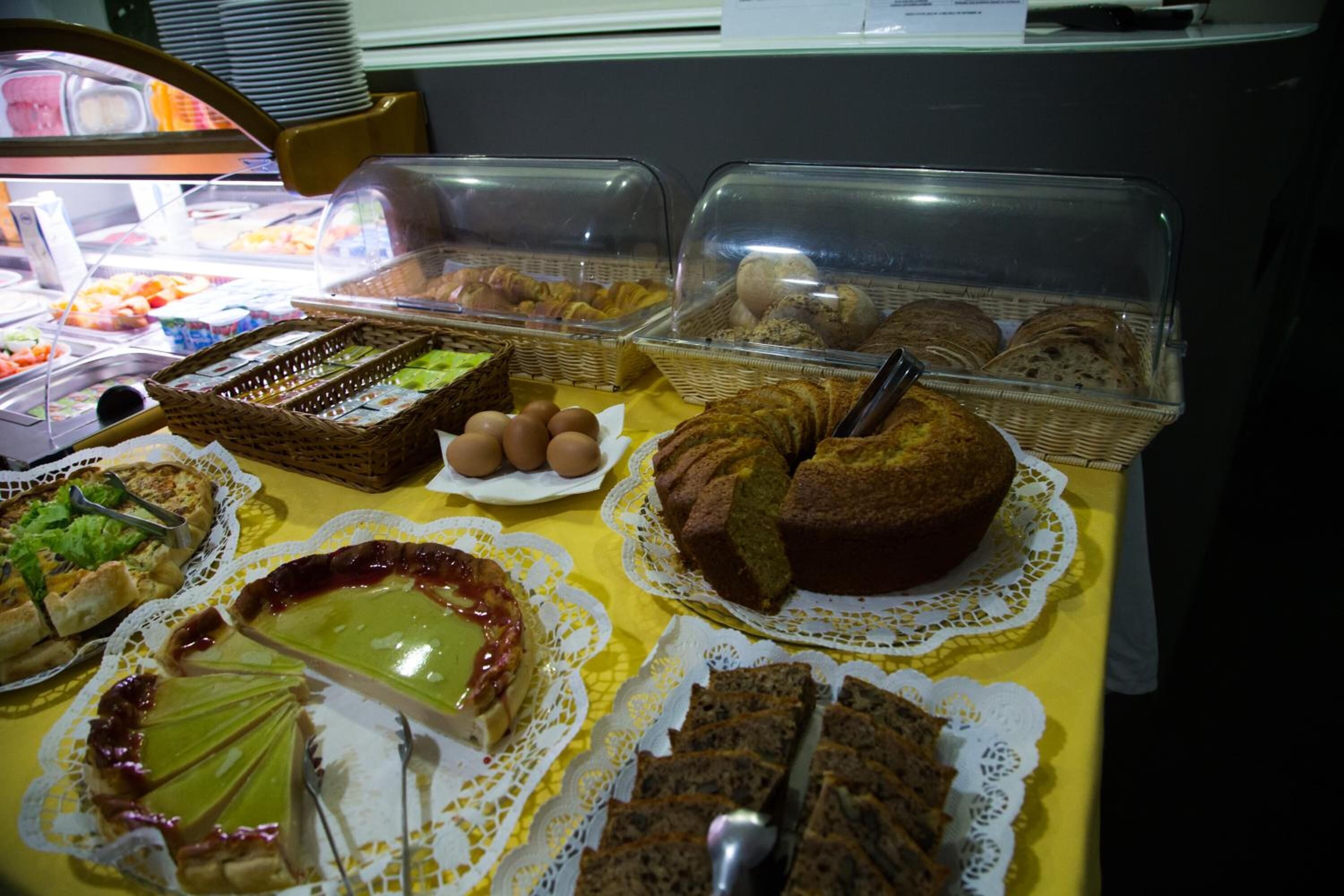 A buffet with various food items including pies, cakes, and bread.