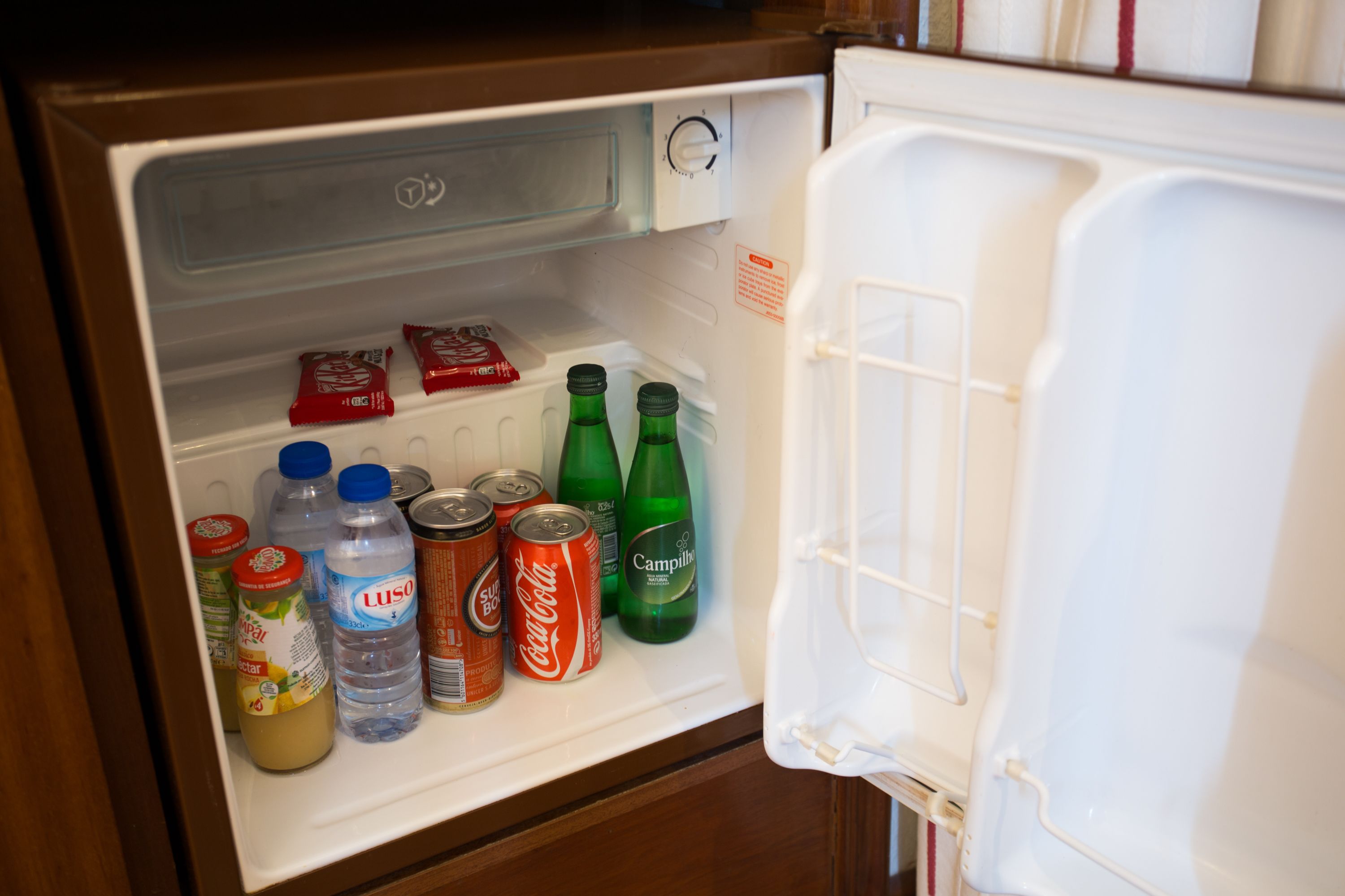 A refrigerator with various beverages and condiments inside.