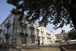 Situated on a cobblestone street, this historic building features ornate balconies and a tiled facade.