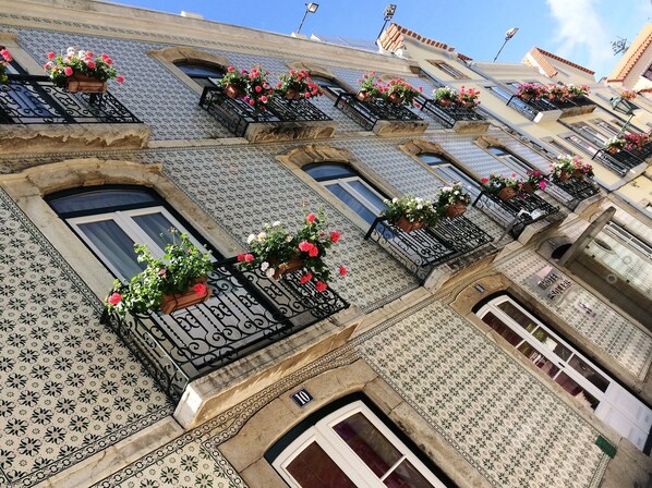 Hotel facade with a distinctive architectural style, featuring balconies with flower boxes and wrought iron railings.