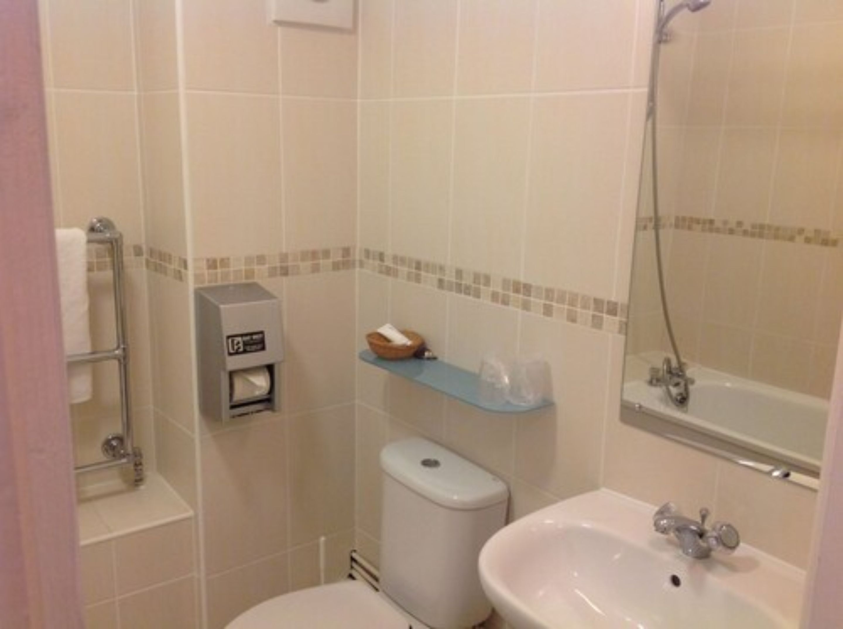 A bathroom with a toilet, sink, and shower.