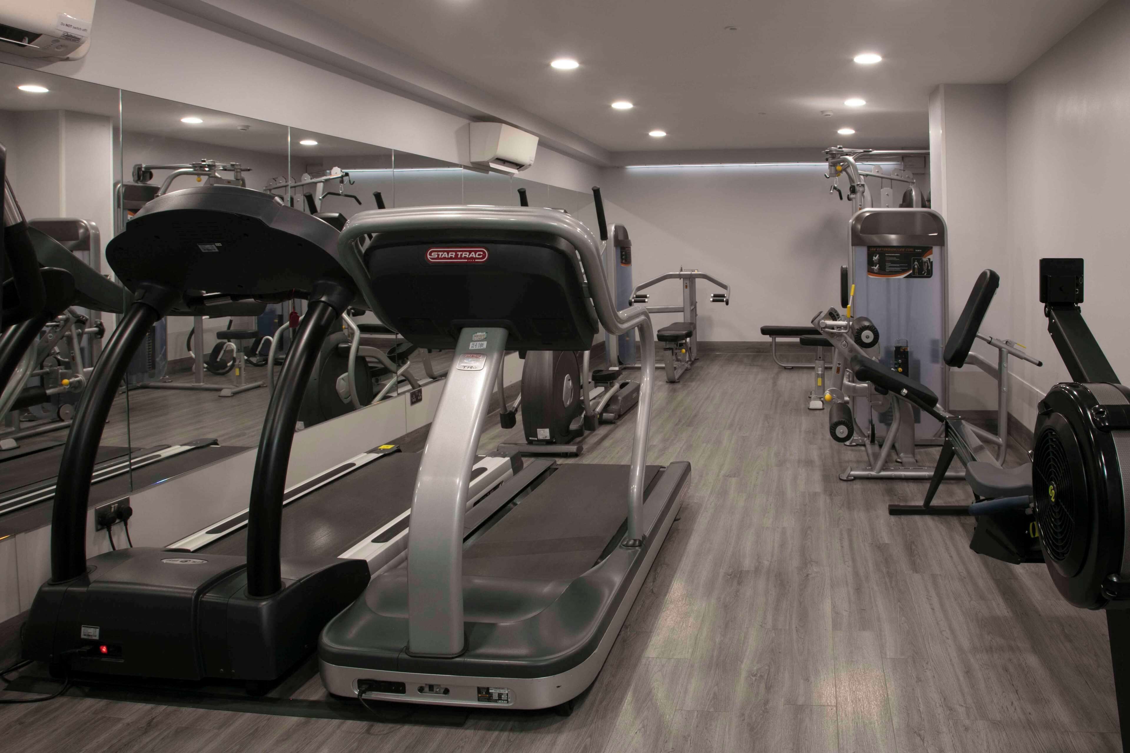 A gym with treadmills, elliptical machines, and weight equipment.