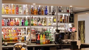 A bar area with shelves of various liquor bottles and a coffee machine. - Best Western Premier Heronston Hotel & Spa (Bridgend)