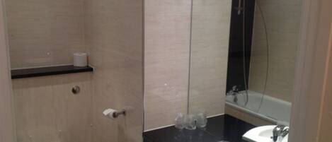 Un baño con inodoro, lavamanos y ducha.