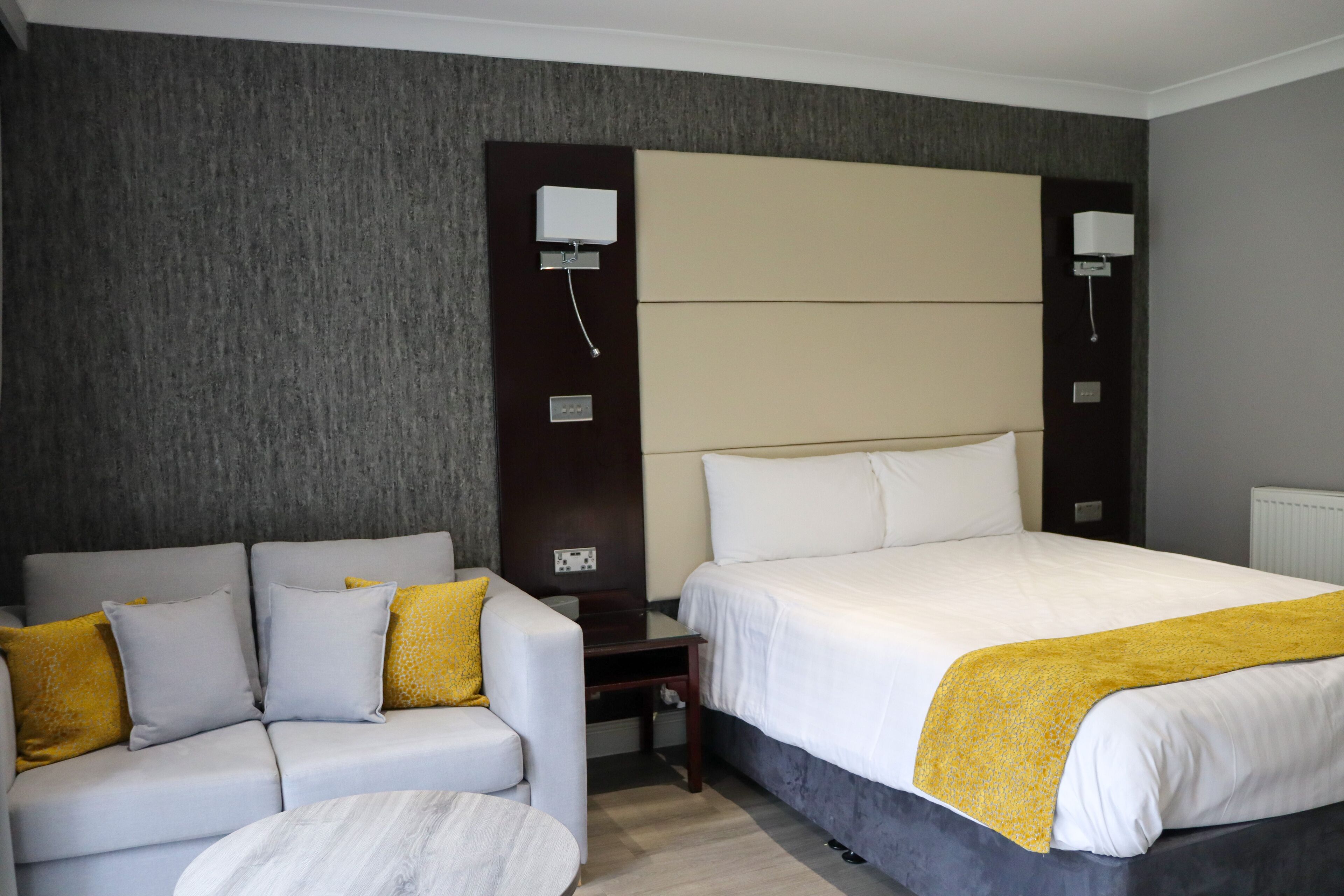 Une chambre d’hôtel avec un lit, un canapé et une petite table.
