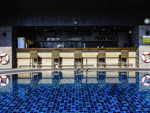 A poolside bar area with a tiled pool, bar counter, and seating. - Avani Ratchada Bangkok Hotel (Bangkok)