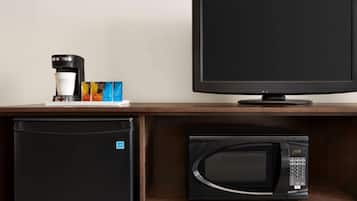 A kitchenette with a coffee maker, microwave, and refrigerator.