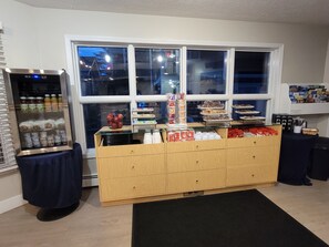 A room with a vending machine, a glass display case with snacks, and a wooden counter with various items. - Pointes North Beachfront Hotel – 2 Person Spa Tub Studios (Traverse City)