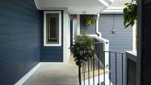 Un'elegante facciata blu scuro con una porta bianca e un piccolo balcone con ringhiera.