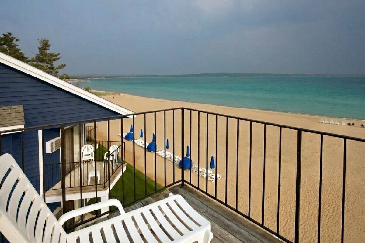 A balcony with a view of a beach and ocean.