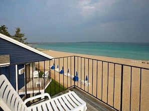 A balcony with a view of a beach and ocean. - Pointes North Beachfront Hotel – 2 Person Spa Tub Studios (Traverse City)
