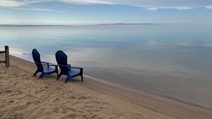 Una spiaggia con due sedie blu rivolte verso il mare.