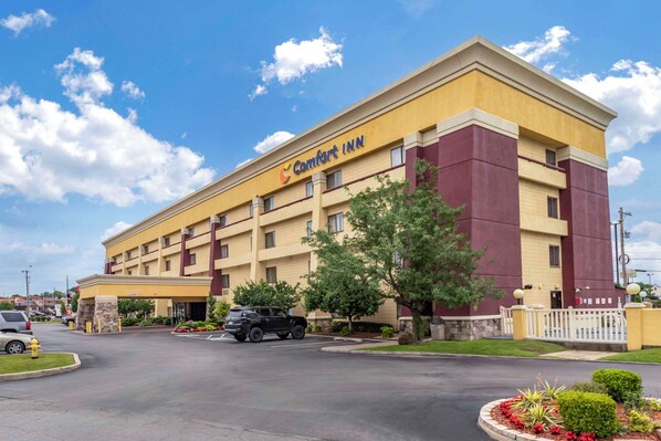 A Comfort Inn hotel with a yellow facade, multiple floors, and a parking lot.