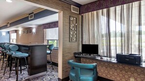 A modern kitchen with a bar area, bar stools, and a large window with curtains. - Comfort Inn Tulsa Midtown (Tulsa)