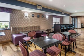 A restaurant with a patterned wall, a bar area, and seating arrangements.