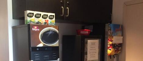 A coffee machine with a coffee cup display, a refrigerator with a fruit display, and a microwave.