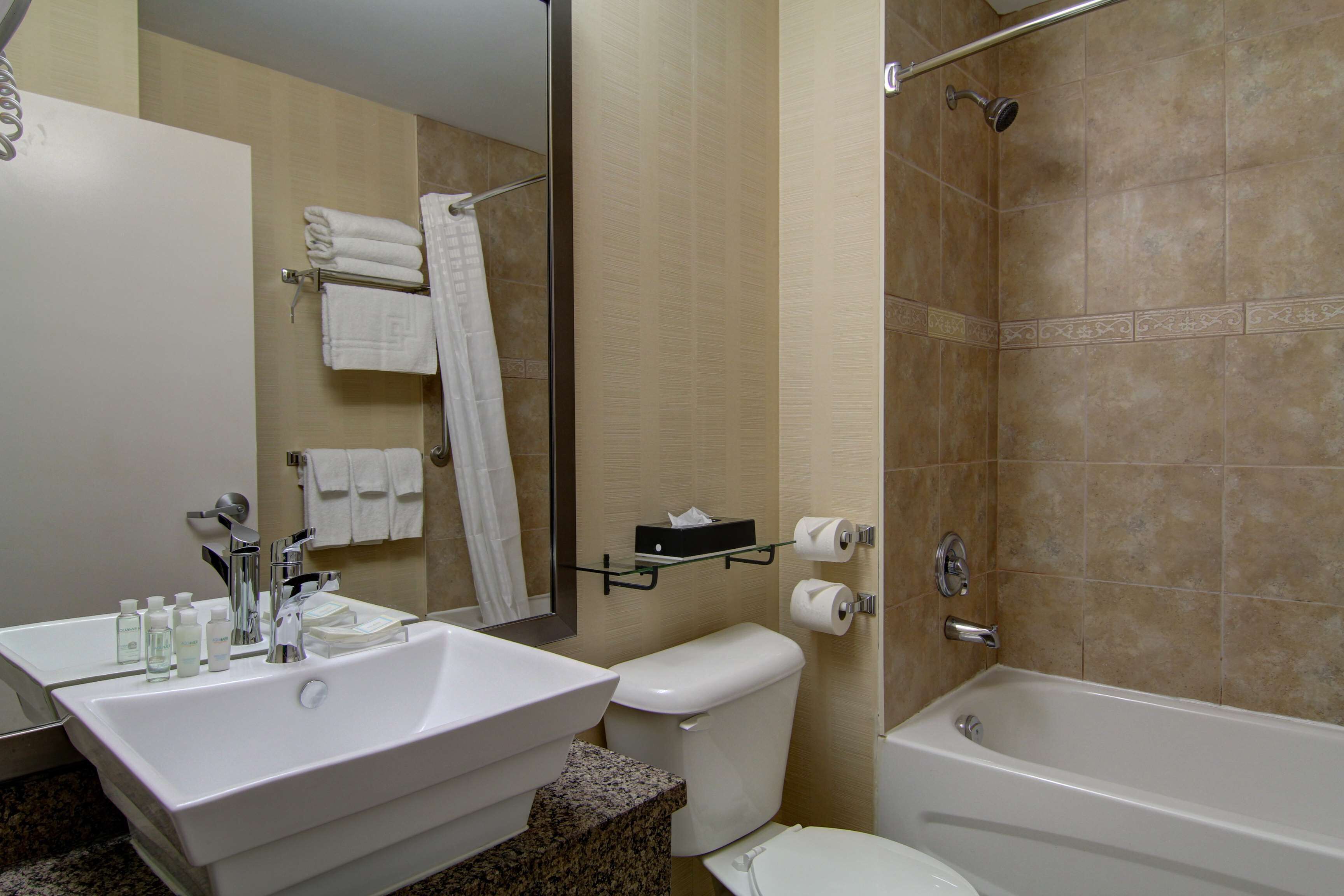 Un baño con lavamanos, inodoro y bañera.