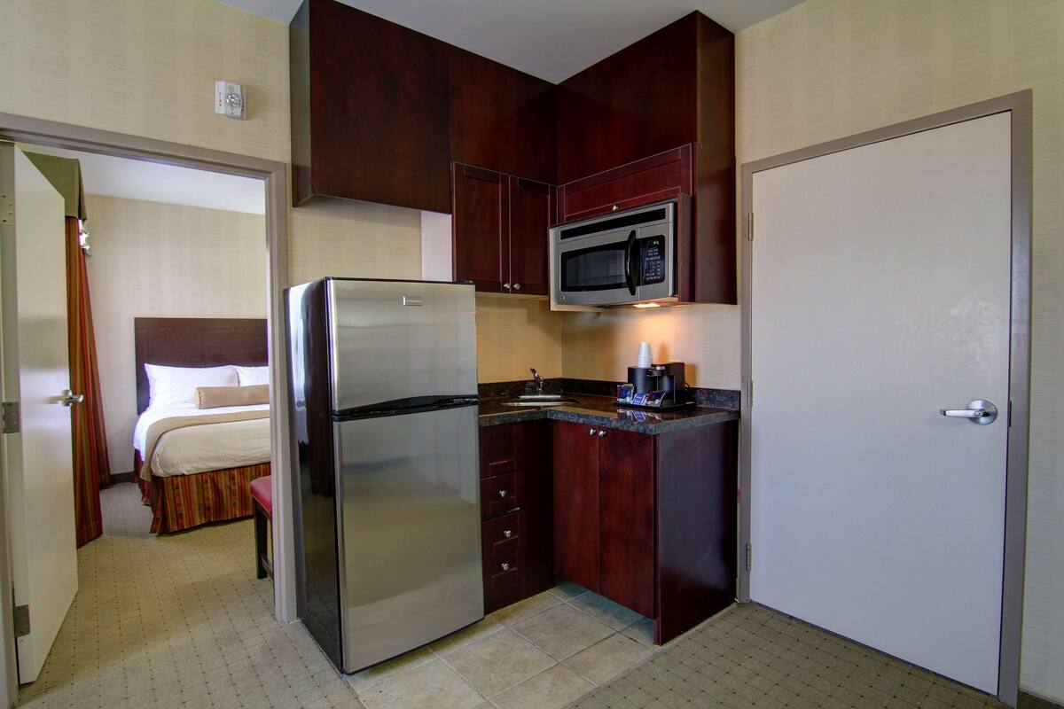 A compact kitchen with a refrigerator, microwave, and coffee maker.
