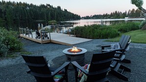 A lakeside deck with a fire pit, outdoor seating, and a dock. - Inn On Long Lake (Nanaimo)