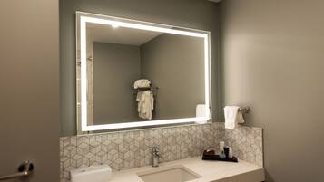 Un baño moderno con un espejo grande, un lavabo y un perchero para toallas.