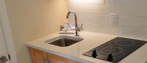 Una cocina compacta con un refrigerador de acero inoxidable, un microondas y un lavaplatos.