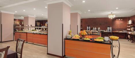 A buffet area with various food items, a coffee station, and seating arrangements.