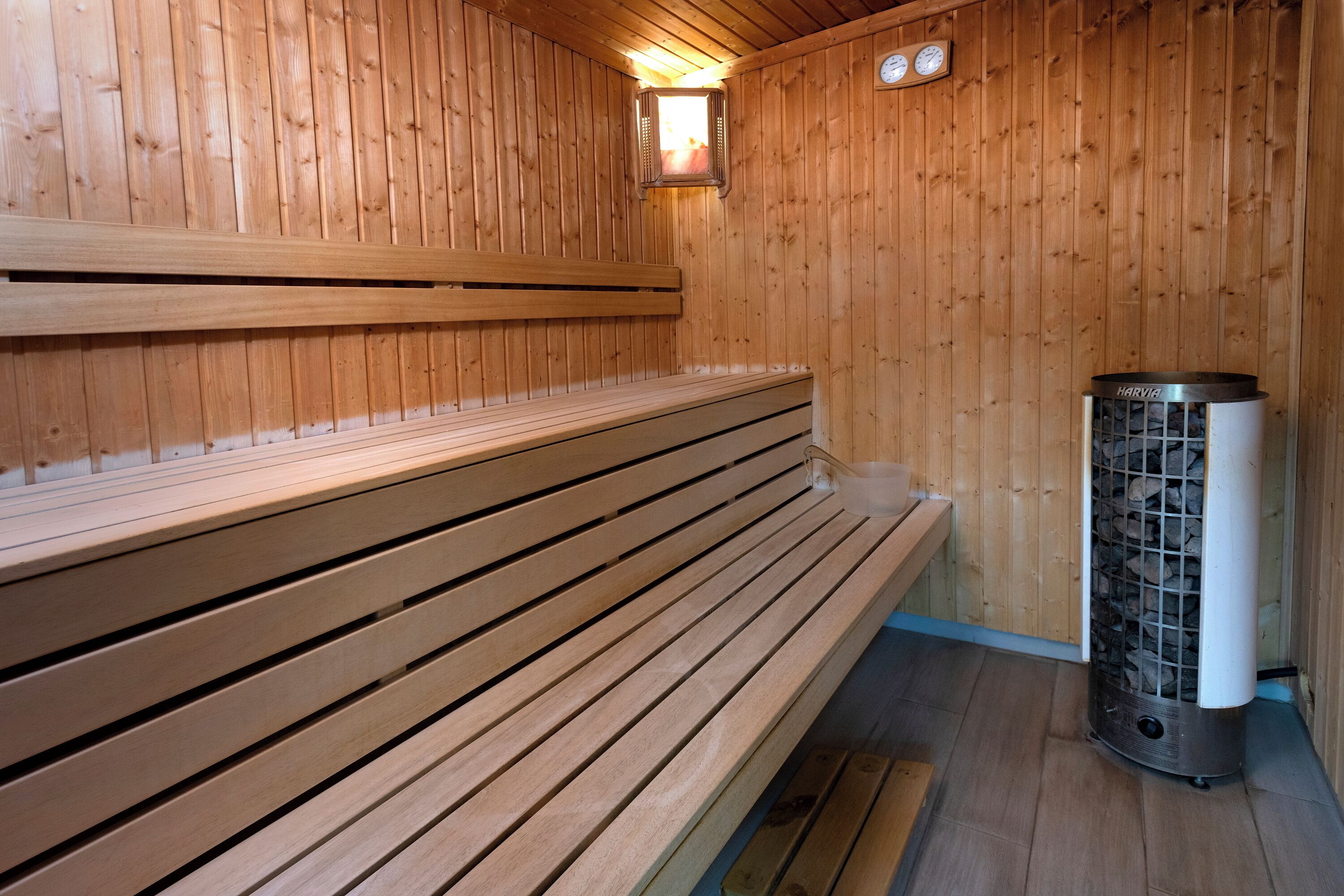A wooden sauna with benches and a central heating unit.