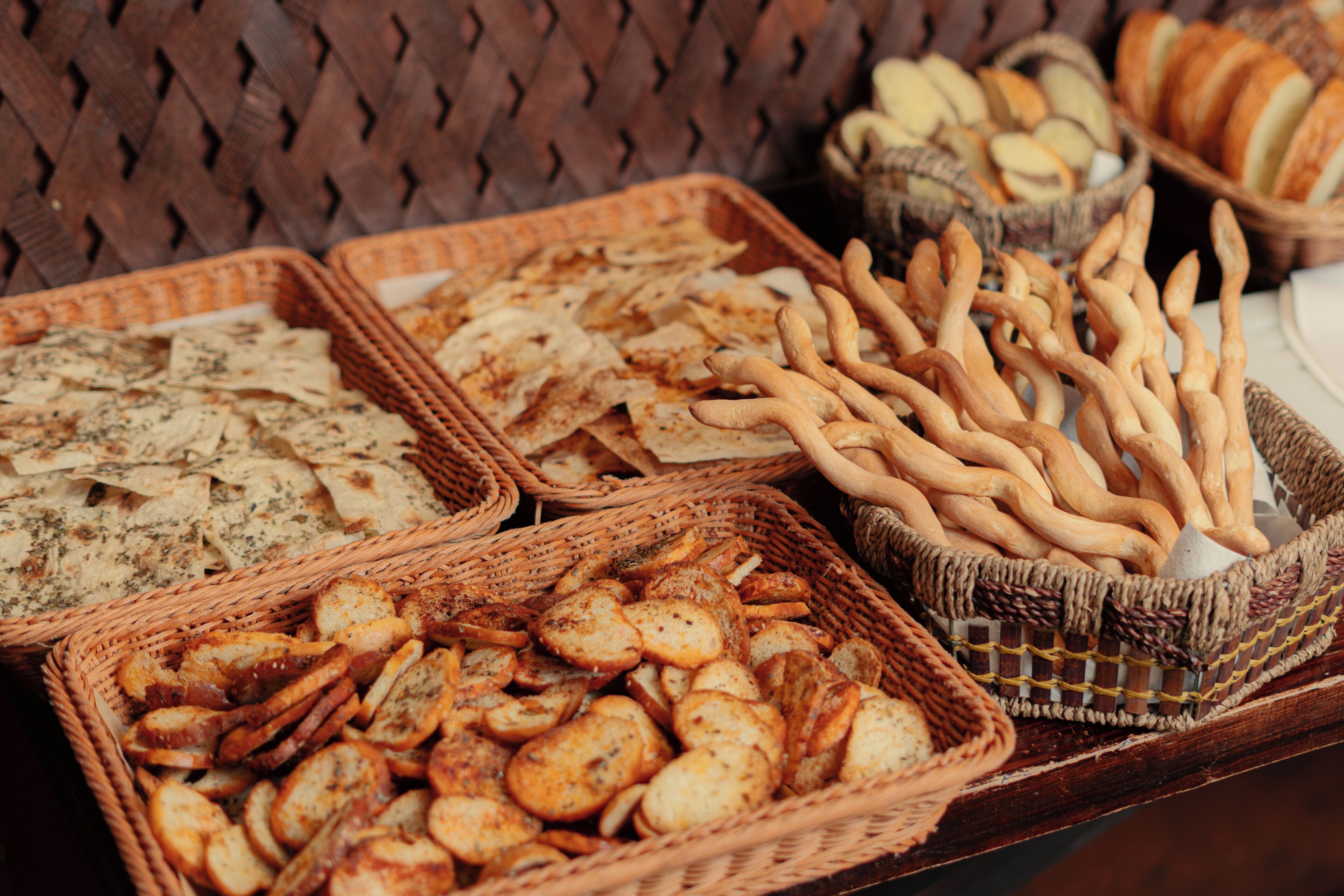 Une variété de pains et de viennoiseries présentés dans des paniers en osier.