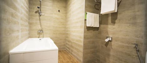 A modern bathroom with a bathtub, a shower, and a towel rack.