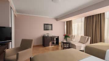 A hotel room with a bed, a desk, a chair, a TV, and a window with curtains.