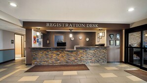 A registration desk with a stone wall backdrop, a reception area, and a tiled floor.