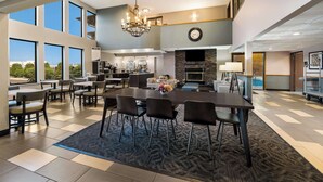 A spacious dining area with a large table and chairs, a chandelier, and a view of the outdoors.