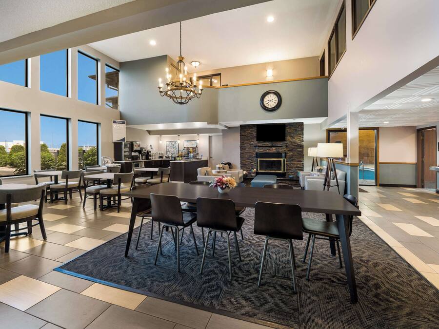 A spacious dining area with a large table and chairs, a chandelier, and a view of the outdoors.