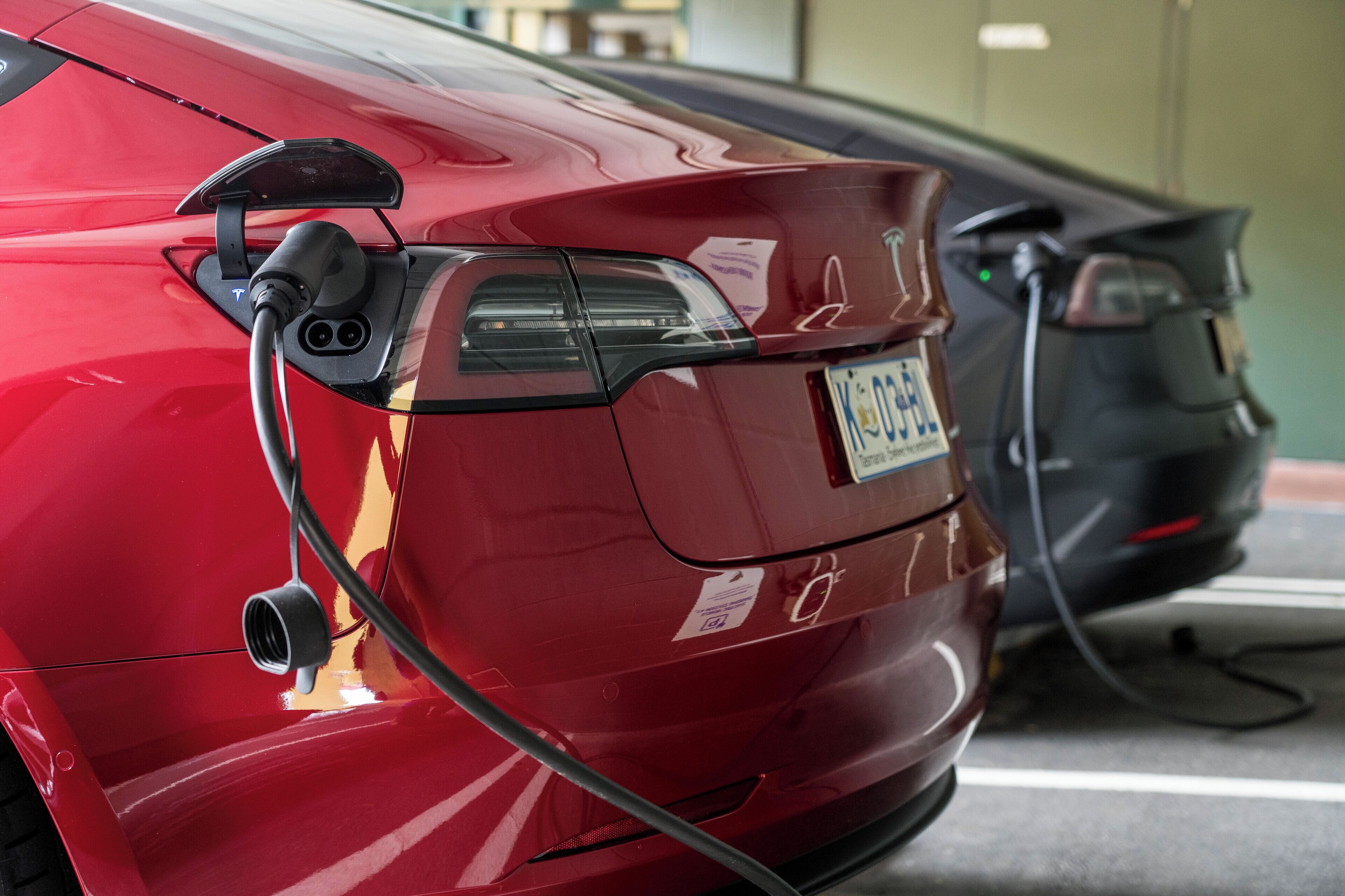 A red car parked at a charging station.