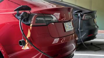 Une voiture rouge est garée à une borne de recharge.