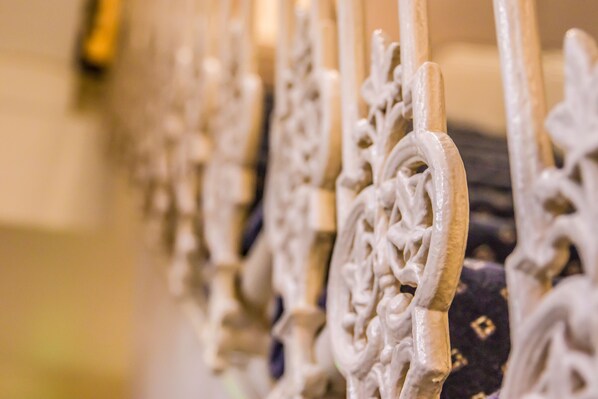 A close-up of ornate, white metal railings with intricate designs, likely part of a historic building's architecture. - London Town Hotel (London)