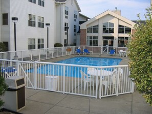 Relax by the pool surrounded by a patio with comfortable seating and scenic views.