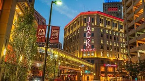 A casino building with illuminated signage, a curved facade, and a parking garage in the background. - Hampton Inn & Suites Cleveland/Independence (Independence)