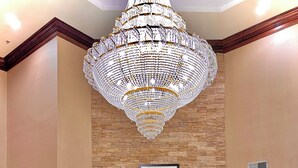 A lobby with a chandelier, a fireplace, blue sofas, and a red carpet. - Comfort Suites Georgetown (Georgetown)
