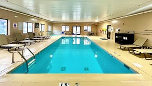 An indoor swimming pool with clear water, surrounded by lounge chairs and a lifeguard chair. - Comfort Suites Georgetown (Georgetown)