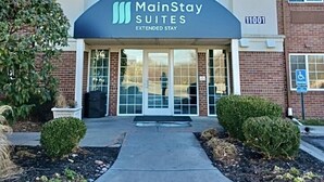 A MainStay Suites Extended Stay hotel with a modern facade, large entrance doors, and a clear sky. - MainStay Suites Kansas City Overland Park (Overland Park)