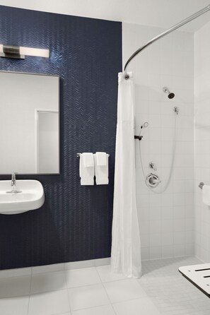 Een bad/douchecombinatie, designer toiletartikelen, een haardroger