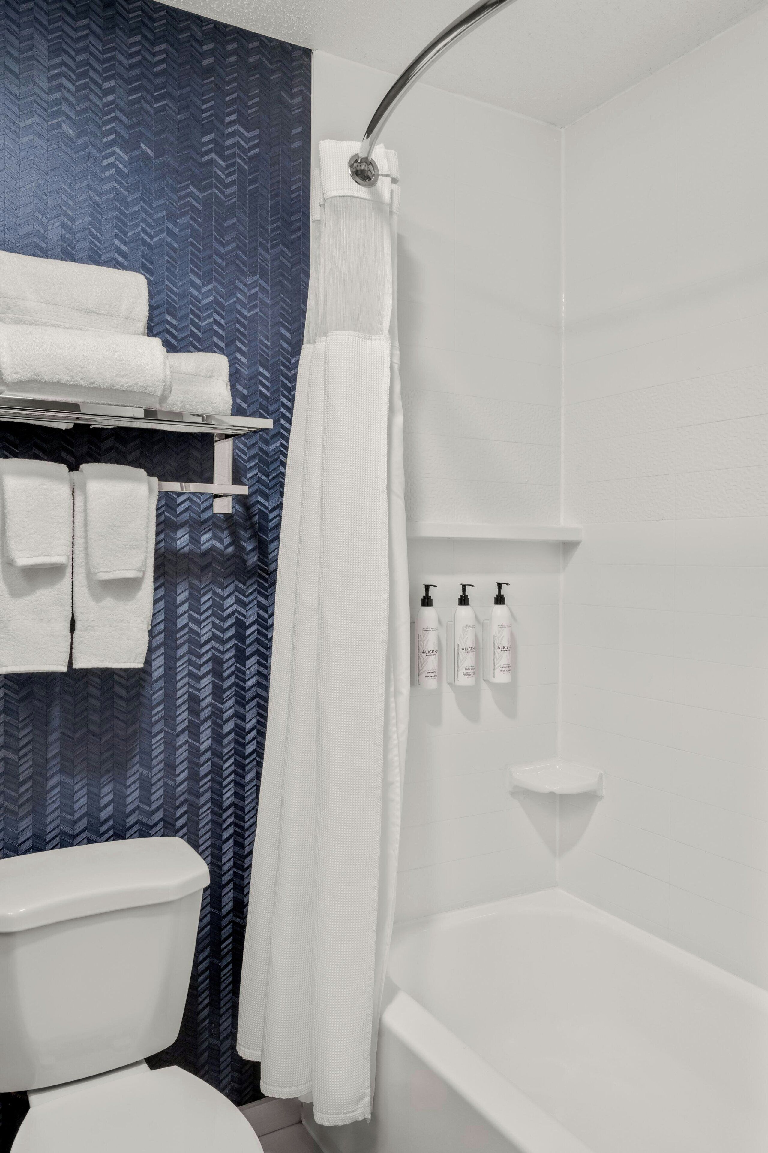 combined shower/bathtub, designer toiletries, hair dryer, towels