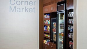 Une petite épicerie de quartier avec des présentoirs réfrigérés et des étagères remplies de collations et de boissons.