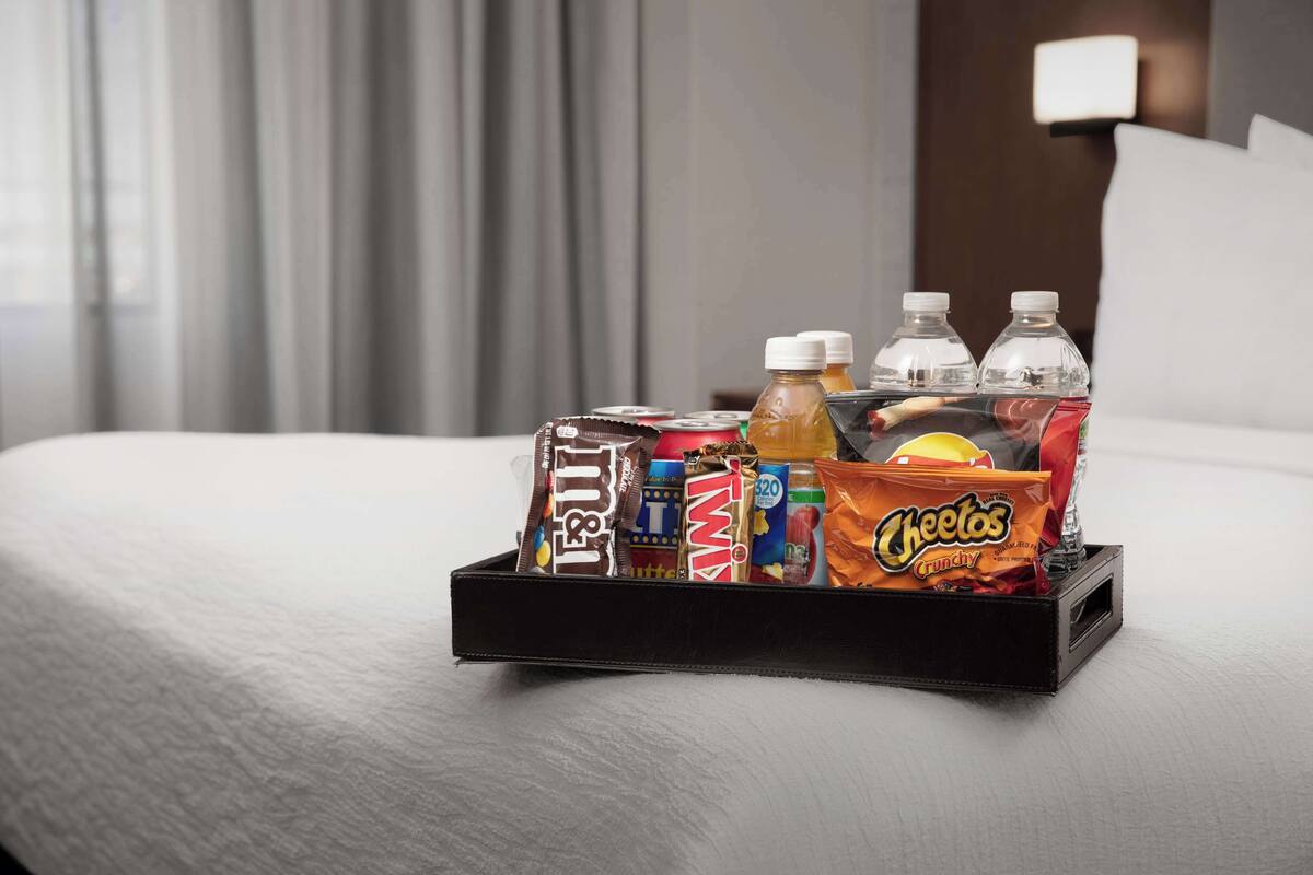 Un plateau avec des collations et des boissons, posé sur un lit.