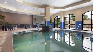 Un espace piscine comprenant un coin salon, des sièges et une vue sur l’extérieur.