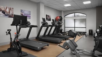 A gym with treadmills, stationary bikes, and exercise equipment.